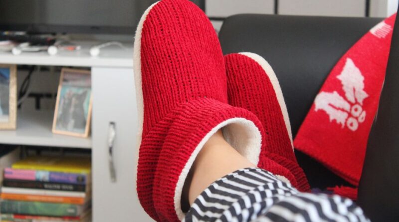 Comfortable relaxation at home with fluffy red slippers and a cozy setting. - Photo by Merve Sayın on Pexels