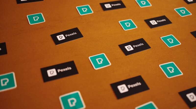 Pexels logos and stickers scattered on a brown background in a creative pattern. - Photo by Matheus Bertelli on Pexels